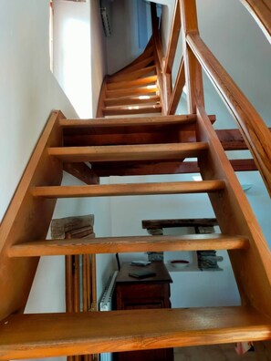 Eine Holztreppe mit Handlauf, die zu einer oberen Etage führt.