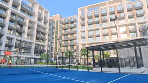 A modern apartment building with multiple balconies, a tennis court, and a covered seating area. - Beverly Boulevard By HMB HOMES (Dubai)