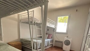 A dormitory room with bunk beds, a window, and a heater. - 3-bedroom house in the Verdon Natural Park (Quinson)