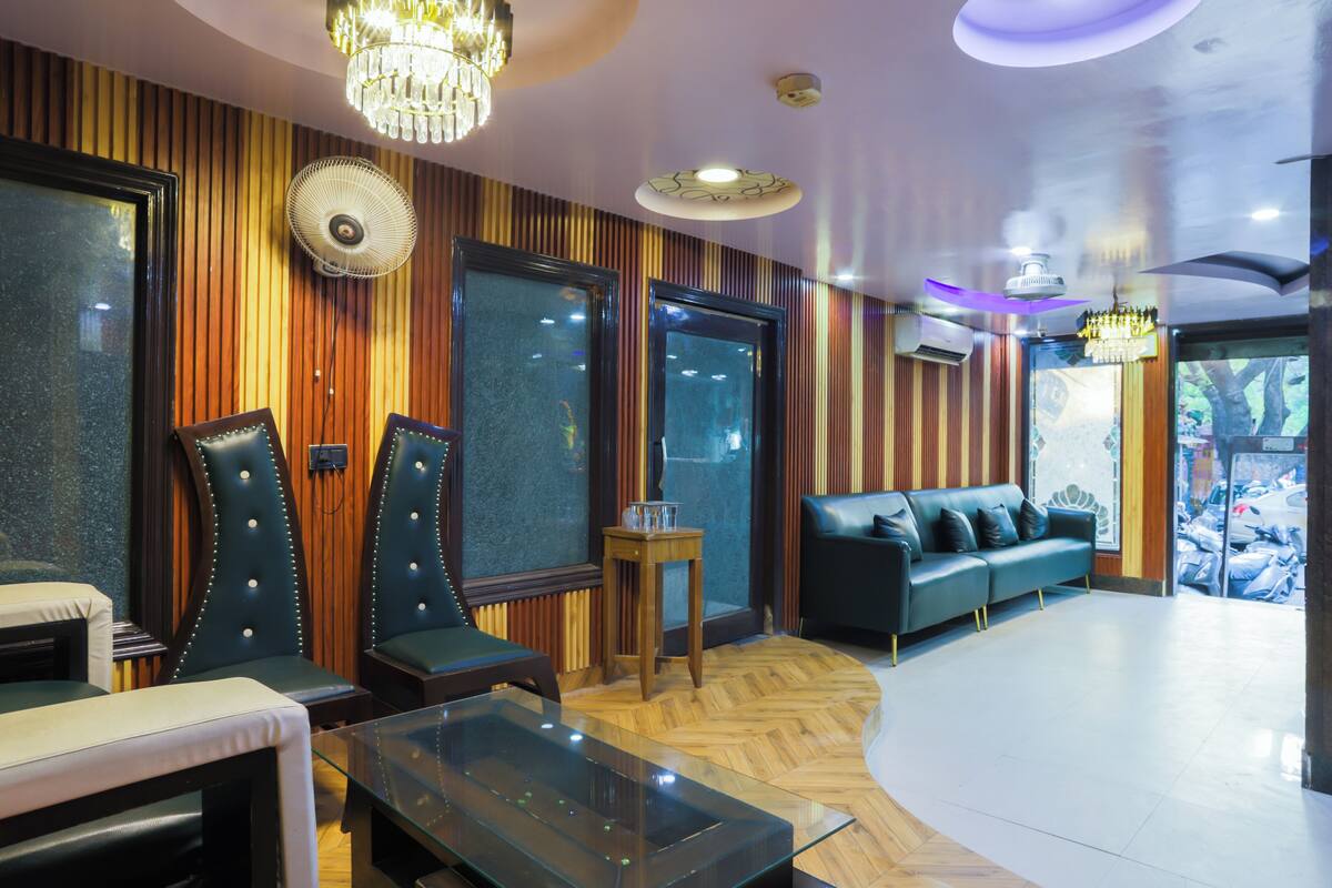 Eine moderne Lounge mit Ledersitzmöbeln, einem Glastisch und einem Parkettboden mit Fischgrätenmuster.