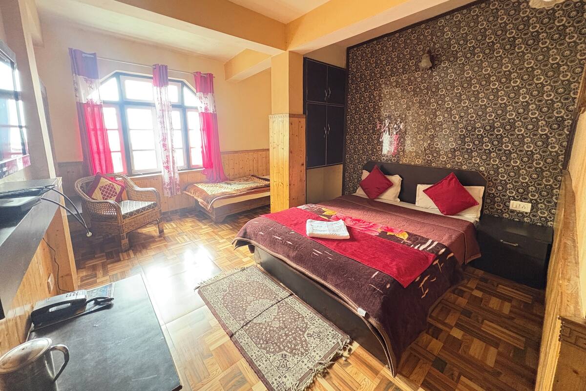 Ein Schlafzimmer mit einem Bett, einem Schreibtisch, einem Stuhl und einem Kleiderschrank.