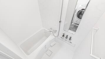Separate tub and shower, hair dryer, slippers, towels