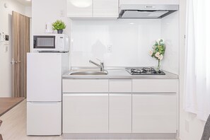 A compact kitchen with a microwave, sink, and stove. - Shinjuku16 (Shinjuku-ku)