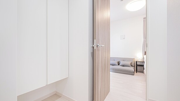 Una habitación con armario, cama, mesita de noche y lámpara.