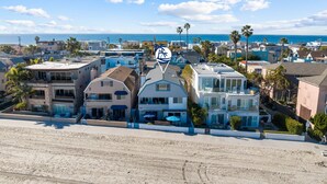 A coastal residential area with houses, palm trees, and a beach. - Remodeled 4BR Bayfront Home | Sleeps 12 | Stunning Views + BBQ Patio (San Diego)