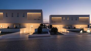 A modern building with a flat facade, large windows, and a well-lit entrance.