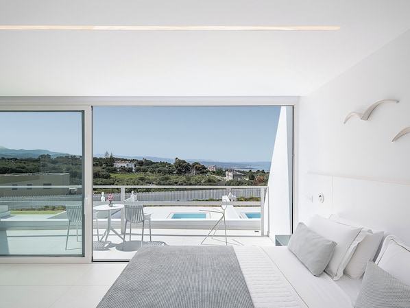 A modern bedroom with a large sliding glass door leading to a balcony with a pool view. - Lagon Life Spirit Design Villas - Adults Only (Chania)