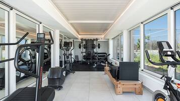 A gym with cardio machines, free weights, and a weight rack.