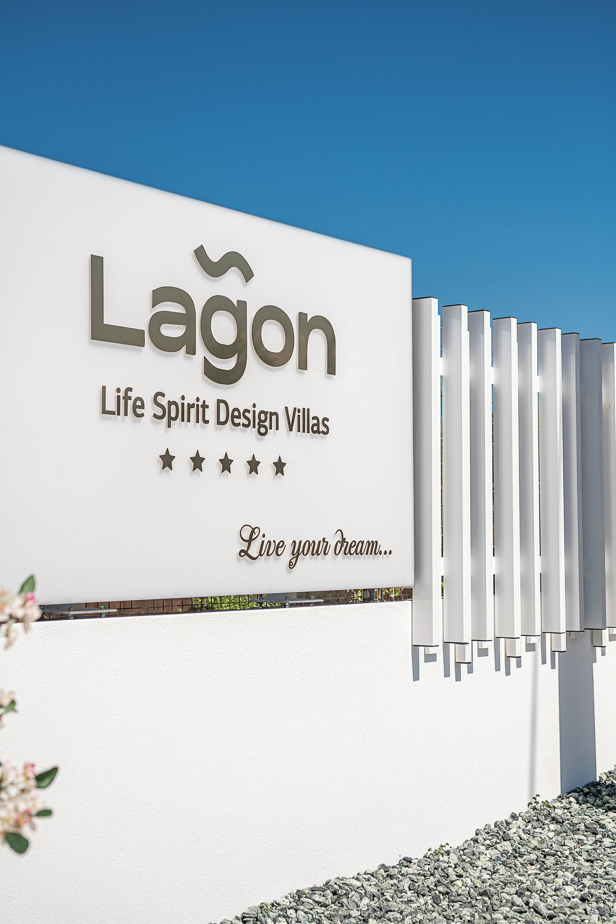 Een bordje voor Lagón Life Spirit Design Villas met een vijfsterrenbeoordeling en de slogan 'Leef je droom...'.