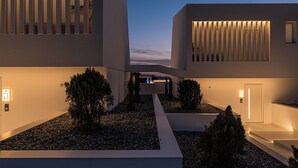 Een modern gebouw met een geometrisch gevelontwerp, een centrale pad en een goed verlichte ingang.