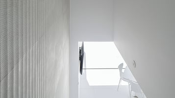 Een modern interieur met een hoge plafond, een schuine plafondconstructie en een uitzicht op de lucht door een raam.