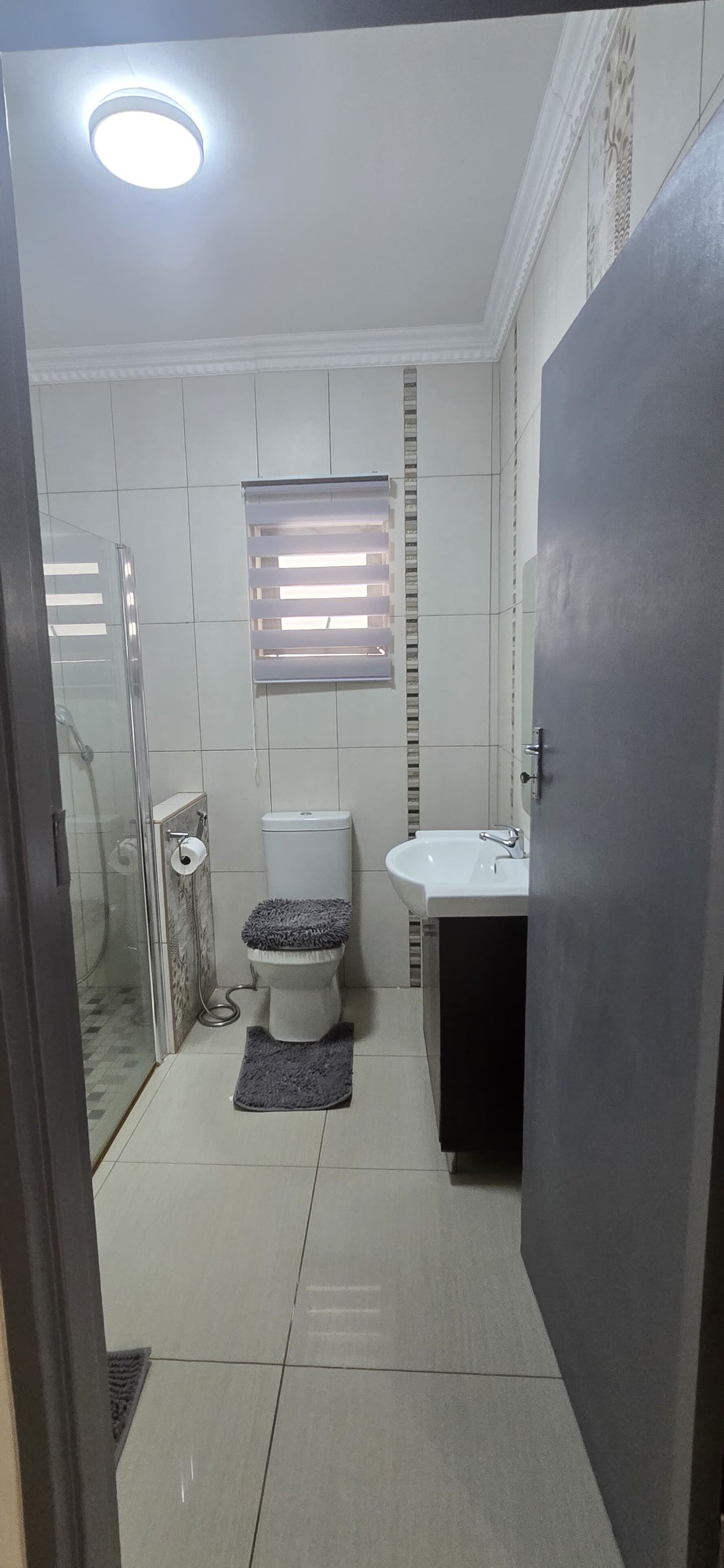 A bathroom with a toilet, sink, and shower.