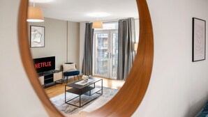Una sala de estar moderna con un televisor de pantalla plana, una mesa de centro y un sofá.