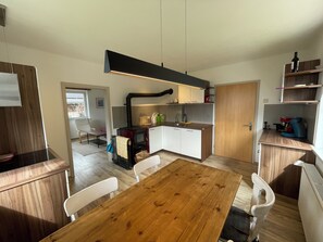 A compact kitchen with a central island, white cabinets, and a built-in stove. - Holiday apartment Arriach Bergzauber (Arriach)