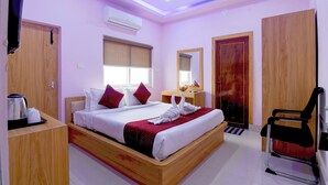 Une chambre d’hôtel équipée d’un lit, d’un bureau, d’une chaise, d’un ventilateur de plafond et d’un appareil de climatisation.