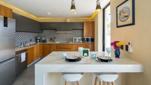 A modern kitchen with a central island, wooden cabinets, and a patterned backsplash. - Casa Nido de Mar 9 Persons Occupancy Pool 7 Beds (Nuevo Nayarit)
