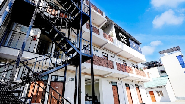 A multi-story hotel with a prominent staircase, balconies, and a clear sky. - Classic Survey Chowk Dehradun (Dehradun)
