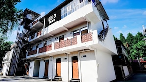 A two-story hotel with a balcony on the upper floor, a sign indicating it is a hotel, and a staircase on the left side. - Classic Survey Chowk Dehradun (Dehradun)