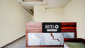 A reception desk with a 'HOTELO' sign, a marble-patterned wall, and a patterned carpet. - Classic Survey Chowk Dehradun (Dehradun)