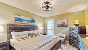 A bedroom with a wooden bed, two bedside tables, a nightstand, a chair, a dresser, and a ceiling fan. - Updated 3BR w/ Gulf Views: Suntide III - Unit 801 (South Padre Island)
