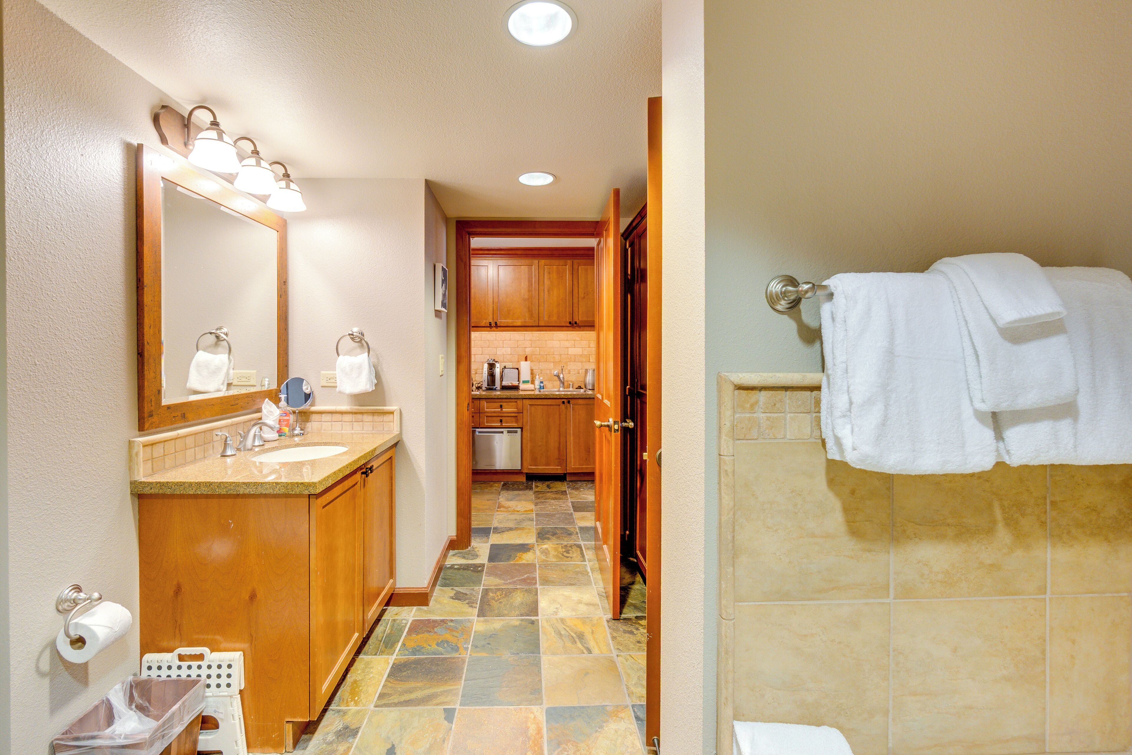 A bathroom with a sink, mirror, and towel rack.