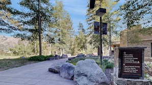 A stone pathway leading to a building with a sign listing amenities such as a spa, fitness center, and pool. - Luxe North Lake Tahoe Getaway in Everline Resort! (Olympic Valley)