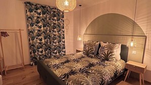 A bedroom with a bed, a nightstand, a wall-mounted shelf, a hanging light fixture, and a window with curtains. - Jacuzzi, Sauna, Private - Escape at your fingertips (Aspach-le-Bas)
