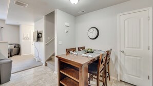 A dining area with a wooden table, chairs, and a clock on the wall. - Nurse-friendly Rental 2 Mi to St Francis Hospital! (Colorado Springs)