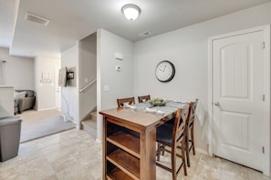 A dining area with a wooden table, chairs, and a clock on the wall. - Nurse-friendly Rental 2 Mi to St Francis Hospital! (Colorado Springs)