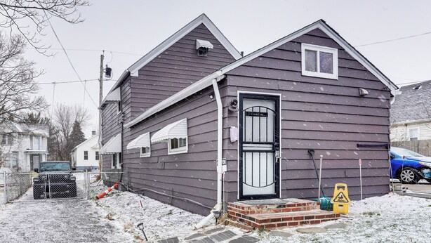 A two-story house with a dark exterior, a front door with a glass panel, and a brick step leading to the entrance. - 8 Mi to Dtwn Cle: Cozy Couple's Retreat w/ Gym! (Cleveland)