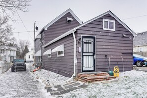 A two-story house with a dark exterior, a front door with a glass panel, and a brick step leading to the entrance. - 8 Mi to Dtwn Cle: Cozy Couple's Retreat w/ Gym! (Cleveland)