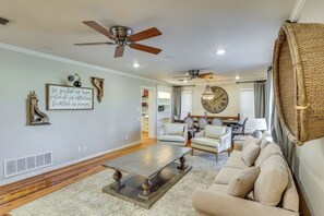 A spacious living room with a large sofa, a coffee table, and a ceiling fan. - 1 Mi to Texas Tech: Group Getaway w/ Pool & Sauna! (Lubbock)