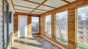 A corridor with wooden walls and large windows, leading to a door. - 1 Mi to Texas Tech: Group Getaway w/ Pool & Sauna! (Lubbock)