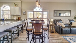 A modern kitchen with a central island, bar stools, and a dining table. - Golf, Gamble & Fish! Condo w/ Pool in Little River (Little River)