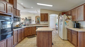 A kitchen with wooden cabinets, a central island, stainless steel appliances, and a tiled floor. - 15 Mi to Kartchner Caverns: Quiet Gem w/ Mtn Views (Benson)