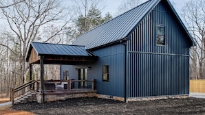A blue metal building with a porch and stone steps. - Serene Couple's Getaway w/ Mtn Views in Bedford! (Bedford)