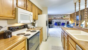 Una cocina con armarios de madera, un refrigerador blanco, una estufa y un lavamanos.