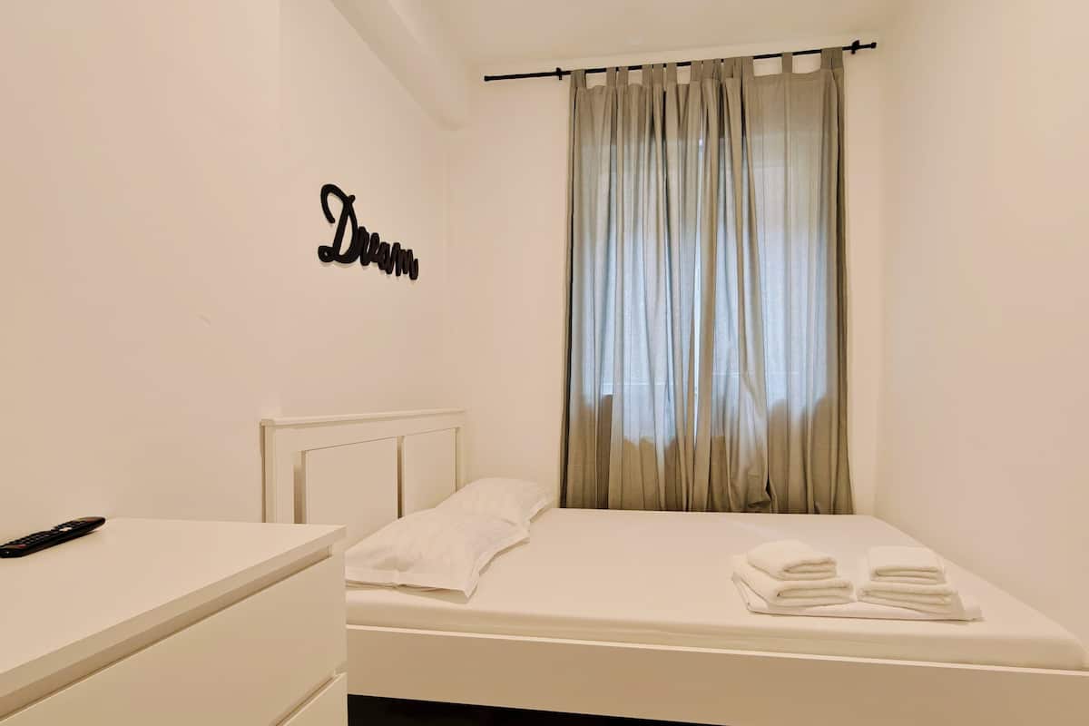 Hypo-allergenic bedding, desk, laptop workspace, blackout drapes