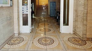 Un pasillo con suelo de baldosas estampadas que conduce a una escalera.