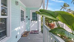A porch with a white door, a mailbox, and a doormat. - A & E's Tranquil Tides at the Truman Annex in Key West (Key West)