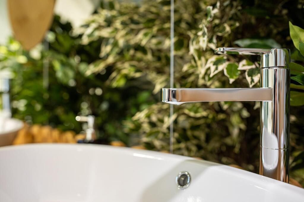 Un baño moderno con grifo cromado y lavamanos blanco.