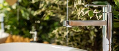 Un baño moderno con grifo cromado y lavamanos blanco.