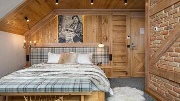 Una camera da letto accogliente con soffitto in legno, copripiumone a quadri e un'ampia finestra vista all'esterno.