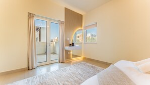 Ein modernes Hotelzimmer mit einem großen Bett, einem Badezimmer mit Waschbecken und Blick auf die Stadt durch das Fenster.
