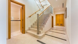 Ein modernes Interieur mit Treppe, Holztüren und Fliesenboden.