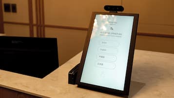 A digital kiosk with a screen displaying a language selection menu.