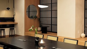 A conference room with a long table, chairs, a potted plant, and a modern light fixture. - Monrêve Cabins Seoul Gangnam (Seoul)