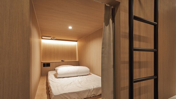 A modern bedroom with a wooden ceiling, a bed with white bedding, and a black metal ladder. - Monrêve Cabins Seoul Gangnam (Seoul)