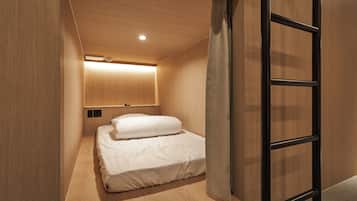 A modern bedroom with a wooden ceiling, a bed with white bedding, and a black metal ladder.