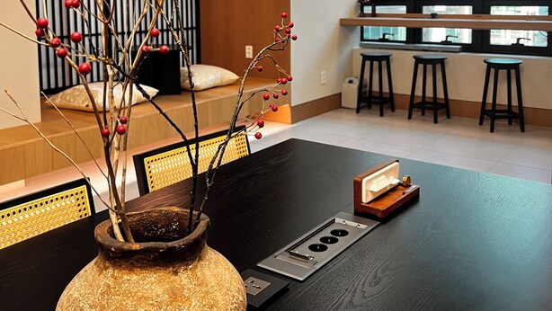 A modern interior with a wooden reception desk, a round wall decoration, and a view of the city through large windows. - Monrêve Cabins Seoul Gangnam (Seoul)